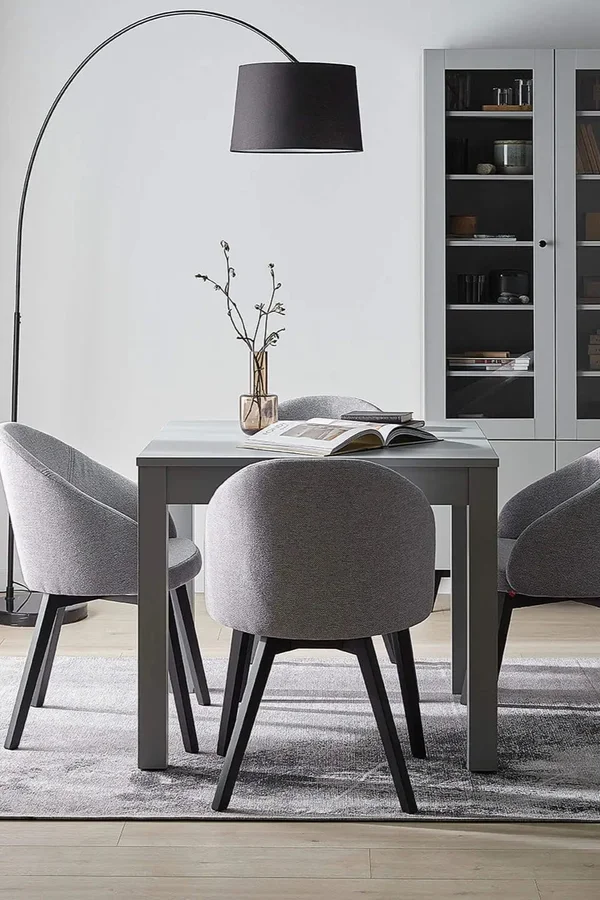 Lampa z dużym kloszem oświetlająca elegancką przestrzeń jadalnianą.